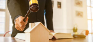 Auctioneer, gavel and little wooden house