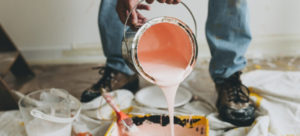 Peach coloured paint pouring into a tray