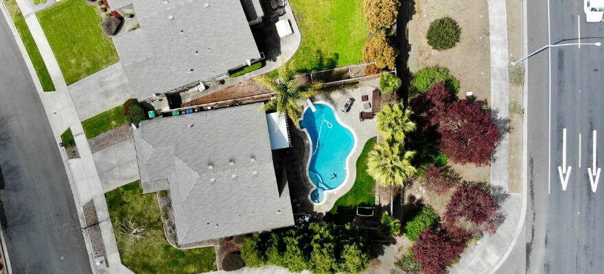 Birds eye view of two houses and a pool